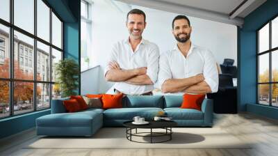 Two business partners standing together in modern office. Portrait of two businessmen in office looking at camera Wall mural