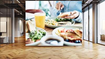 Woman having delicious and healthy breakfast in restaurant. Close up of nutritious food Wall mural