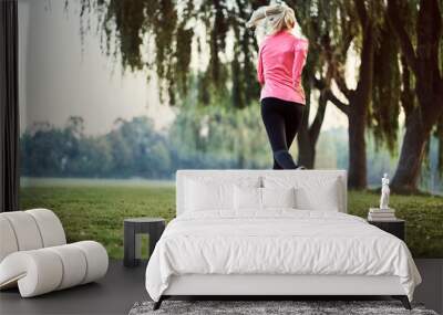 Woman running during foggy autumn morning in park Wall mural