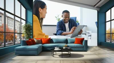 Young African businessman pitching new ideas to female coworker Wall mural