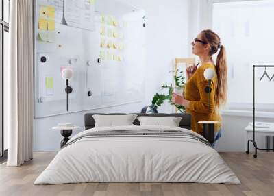 Young businesswoman planning on whiteboard in startup office Wall mural