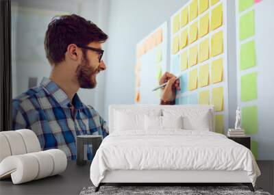 Young creative designer working on startup business in his office Wall mural