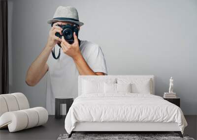 Young man taking picture with analog camera isolated on grey background Wall mural