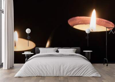 two candles burning and shining bright isolated on black background concept Wall mural