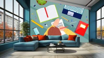 Child at the table with school supplies doing homework. Student with a pencil in his hands. Study concept Wall mural