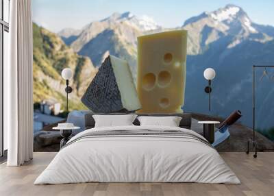 Cheese collection, French emmental, tomme and reblochon de savoie cheeses served outdoor in Savoy region, with Alpine mountains peaks on background Wall mural