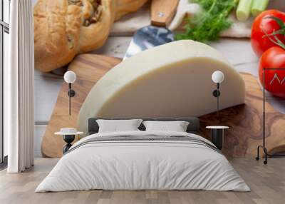 Italian cheese, Provolone dolce cow cheese from Cremona served with olive bread and tomatoes Wall mural