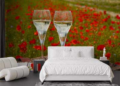 Picnic on red poppies flowers field and green grass with glasses of champagne sparkling wine, cremant  or cava, summer in France, weekend background Wall mural