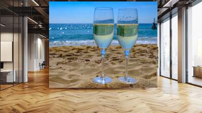 Summer time in Provence, two glasses of cold champagne cremant sparkling wine on famous Pampelonne sandy beach near Saint-Tropez in sunny day, Var department, France Wall mural