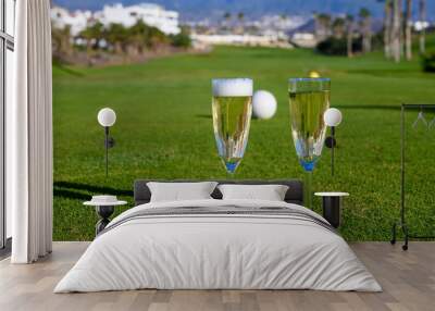 Two glasses with  bubbles white champagne or cava wine served on green golf club grass with mountains view during golf competition event or celebration Wall mural