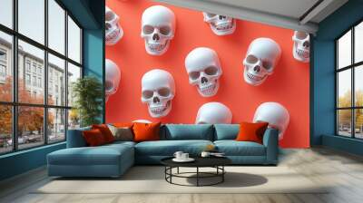 A symmetric arrangement of white human skulls is displayed on a bright orange background, creating a modern and striking visual that is perfect for themes involving mortality or Halloween. Wall mural