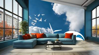 Offshore wind turbines producing sustainable renewable green energy set against a blue cloudy daytime sky Wall mural