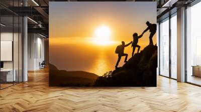 Group of people climbing a mountain in silhouette, helping each other to reach the summit. Teamwork and shared goals concept. Wall mural