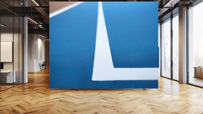 Lines on edge of indoor synthetic football pitch with blue surface. Low angle close up, shallow depth of field. Wall mural