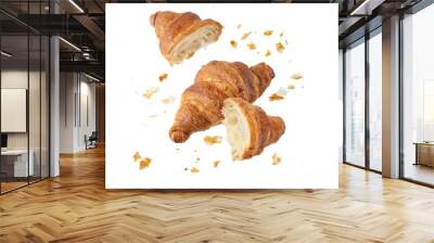 Fresh baked butter breakfast croissants and crumbs falling flying isolated on white background. Whole and broken in half croissants. Wall mural