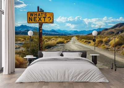 A yellow road sign stands under a clear sky, asking WHAT'S NEXT? against the backdrop of a winding desert road, symbolizing uncertainty and future possibilities Wall mural