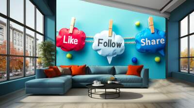 Engagement concept with Like, Share, Follow speech bubbles pinned on a string against a soft blue background, representing social media interaction and online community engagement Wall mural