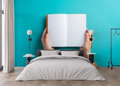 Hand holding blank brochure or book mockup on blue background, showcasing offset paper leaflet or booklet template in first person view Wall mural