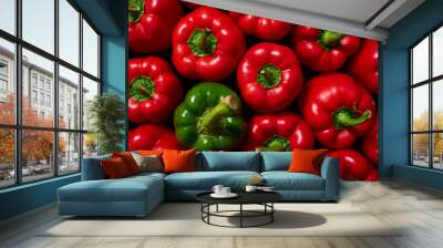 A single green sweet pepper surrounded by a group of red peppers. Sweet green and red bell peppers, top view. Wall mural