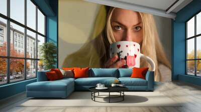 Sexy young beautiful blonde Woman looking at viewer drinking tea Wall mural