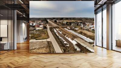 Zabiezki, Poland, 2020. Aerial view on railway line construction site in small village near Otwock and Warsaw. Railway components ready to deploy. Train tracks underlay and concrete ties. Wall mural