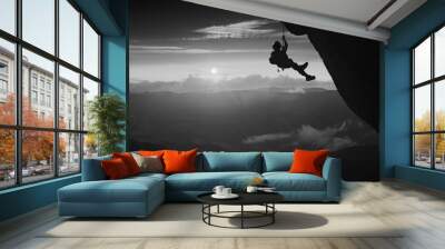 Climber against sunset background. Black and white Wall mural