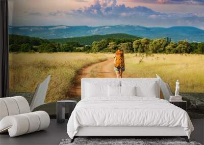 girl hiker on a trail on the pages of book Wall mural