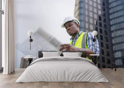 african male civil engineer inspects a commercial building construction site in a real estate projec Wall mural