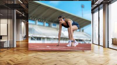 Beautiful Asian girl running at outdoor treadmill in sports stadium, Taking care of health and exercise for modern teenagers. Wall mural