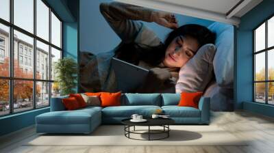 Caucasian women are using the tablet computer on the bed before she sleeping at night, Mobile addict concept, Blue light harmful to the eyes. Wall mural