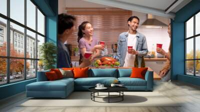 Group of Asian friends enjoying an evening party together at home. Wall mural