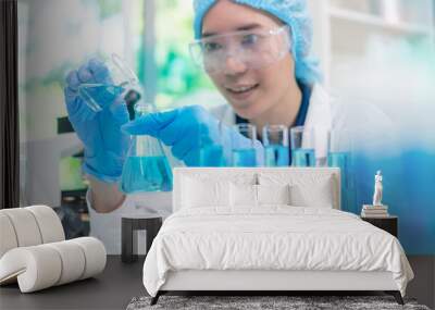 Scientist wearing glassware research in chemistry laboratory for pharmaceutical using beaker and test tube equipment for analysis microbiology Wall mural