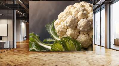 Close-up of a Fresh Cauliflower Head with Green Leaves Wall mural