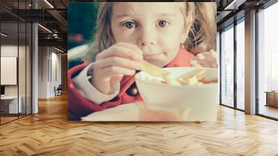 Cute little girl eating fries and ketchup Wall mural