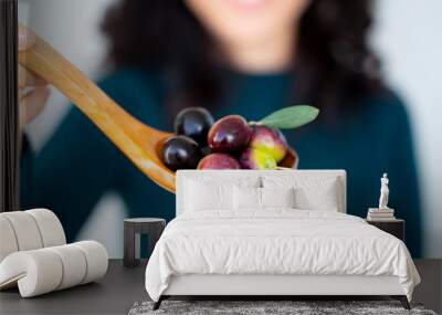 A handful of Mediterranean olives on a wooden spoon Wall mural