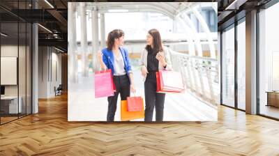 Happy shopping asia woman with a group of friends at the background. Wall mural