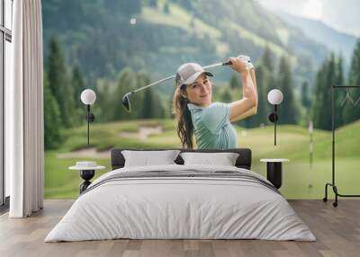 Beautiful young female professional golfer is playing golf in a tournament on a beautiful golf course. Wall mural