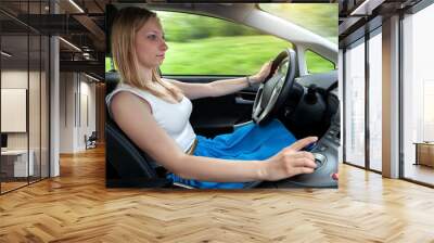 Young woman not fastened a seat belt is driving a car Wall mural