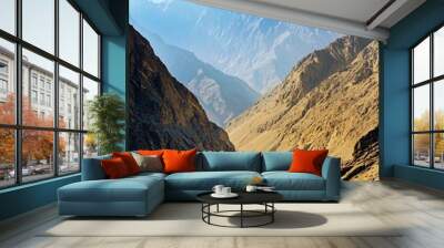 A breathtaking view of a valley surrounded by majestic mountains, bathed in the warm glow of the morning sun. Wall mural