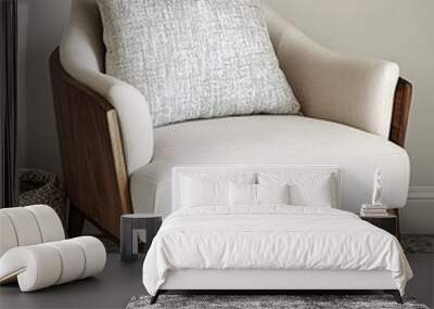 A white armchair with a wooden frame and a patterned cushion sits on a patterned rug. Wall mural