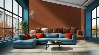 Modern sectional sofa with brown and cream cushions in a living room with a brown wall. Wall mural