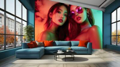 A vibrant night club image showcasing two beautiful Asian women dancing and posing glamorously together on the dance floor, illuminated by striking neon lights in a lively club atmosphere. Wall mural