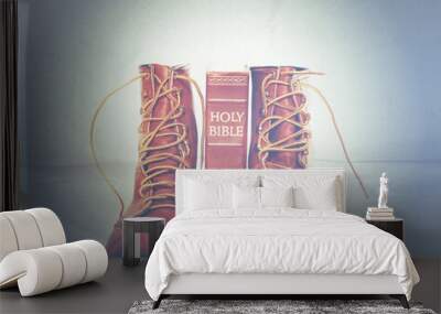 Bible and boots on gray background Wall mural