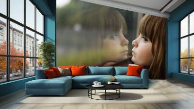 Little girl looking through window Wall mural