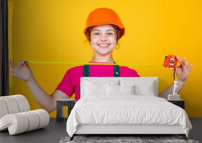 This will be perfect. kid wear helmet on construction site. teen girl builder with building tool tape measure. child on repairing work. concept of renovation in workshop. busy professional carpenter Wall mural