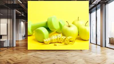 Tube of measuring tape on yellow color, several apples Wall mural