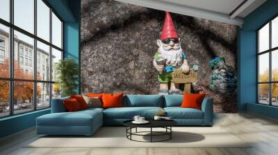 A happy garden gnome on vacation, holding a margarita next to a welcome sign. Wall mural