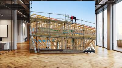 AUCKLAND, NEW ZEALAND - Dec 04, 2019: Construction site with wooden frame and worker on roof Wall mural