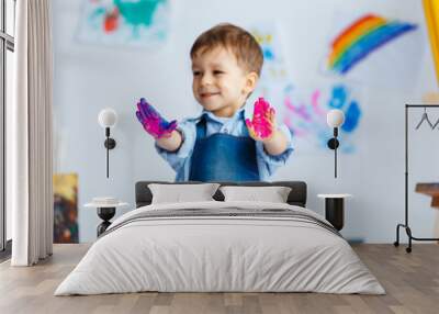 cute, happy, white, three year boy in blue shirt and jeans showing his dirty hands in watercolors. l Wall mural