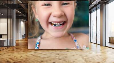 Little girl with orthodontics appliance and wobbly tooth Wall mural